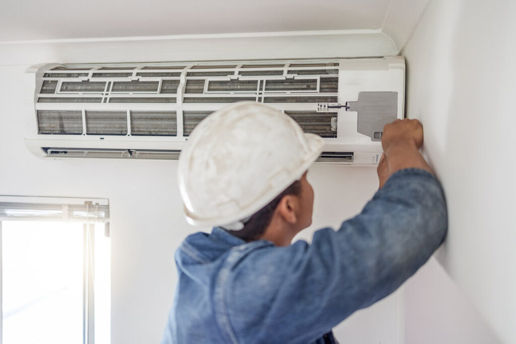 A professional technician is repairing AC unit and building HVAC maintenance